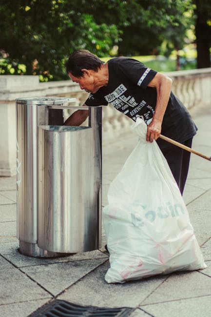 Two large plastic rubbish bags, filled with unknown waste, are placed on the pavement near the edge of a residential street. The bags appear to be made of thick, transparent plastic, with some section